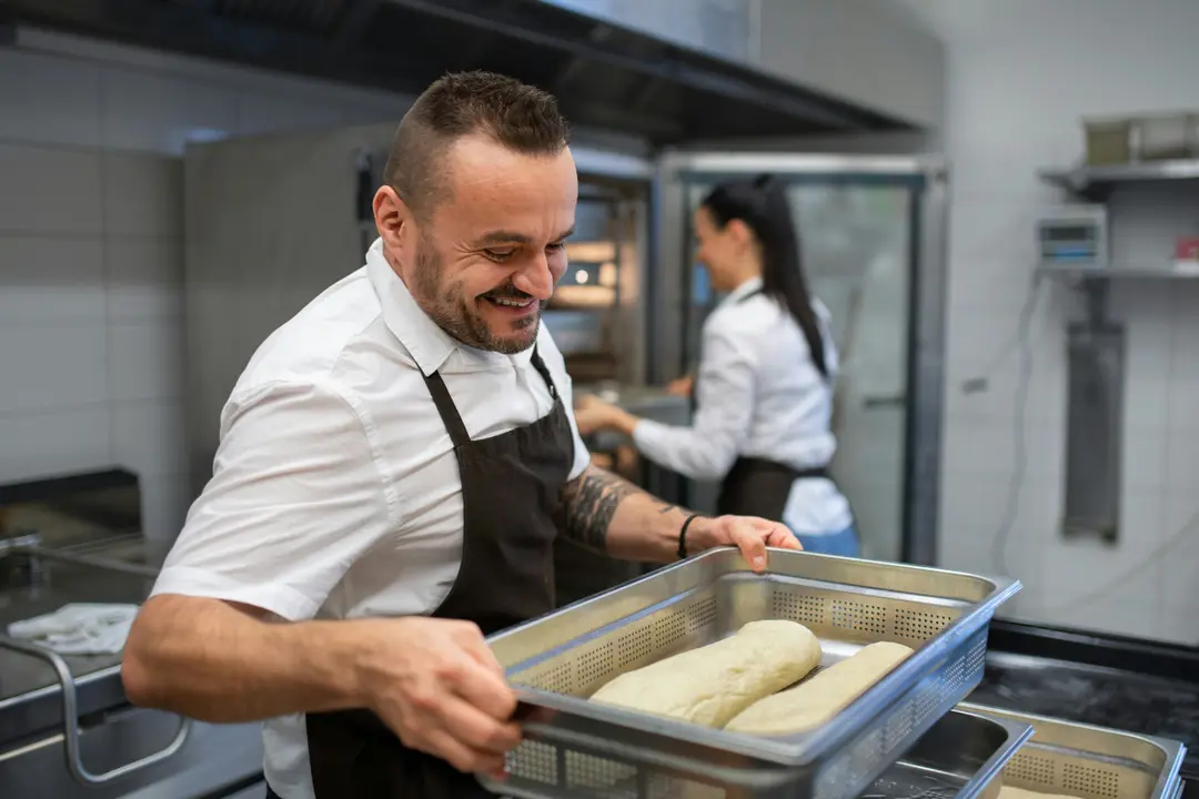 This image captures a moment of activity and positive interaction in a professional kitchen, featuring two staff members.