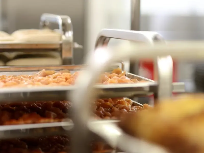 This is an image of food preparation within a commercial kitchen environment, likely a ghost kitchen.