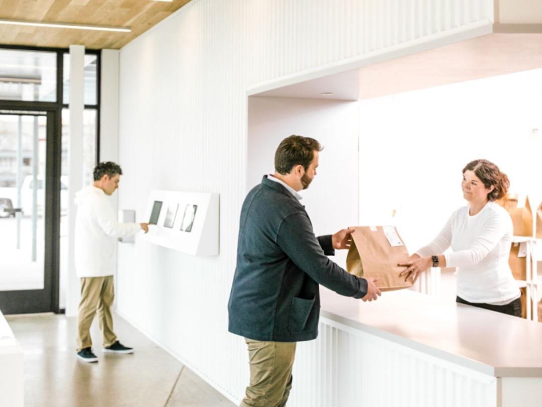 A man getting a take out food in a ghostkitchen processing center