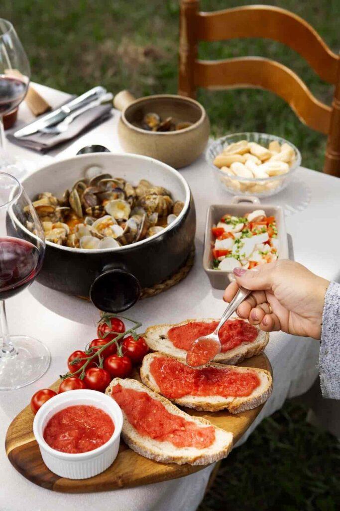 A photograph of a table with seafood, bread, and spreads.