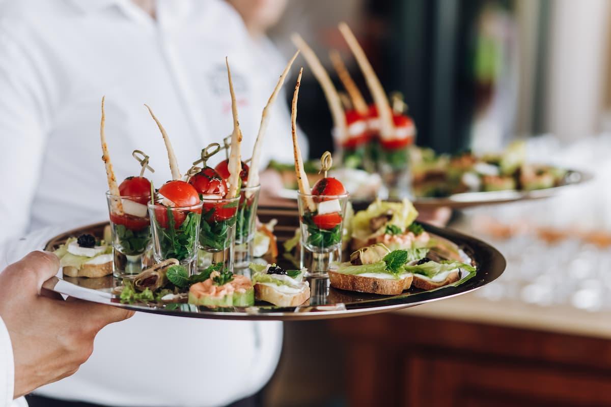 Photograph of a waiter offering appetizers.