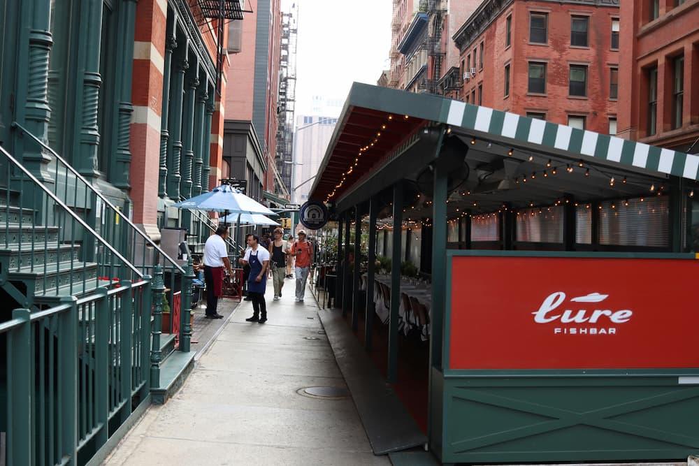 xterior view of a restaurant on a busy street, highlighting the restaurant's facade and people around