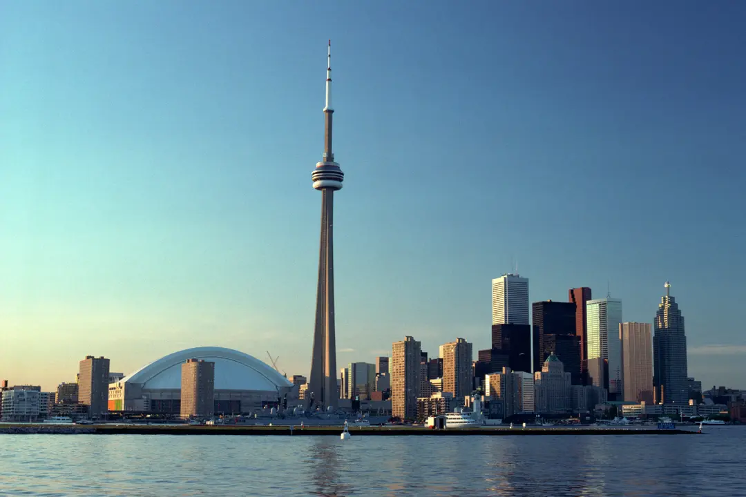 This is an iconic photograph of the Toronto, Canada skyline, taken from a vantage point on Lake Ontario.