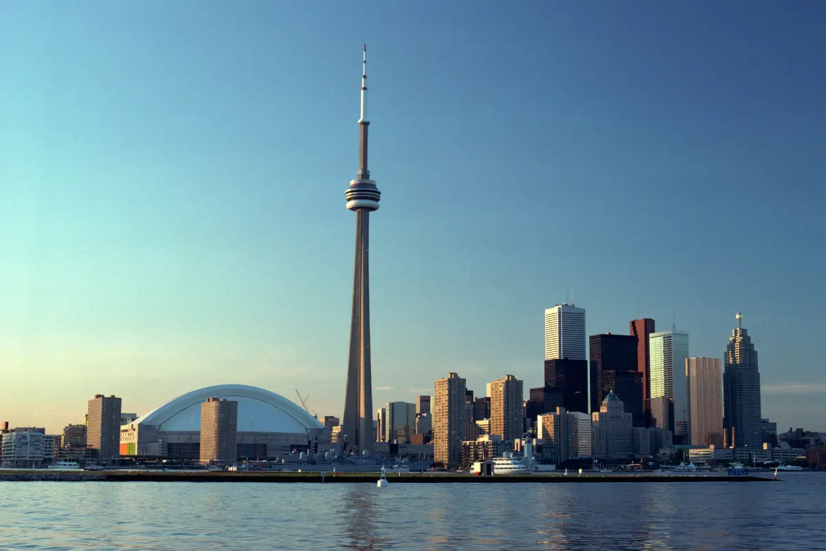 This is an iconic photograph of the Toronto, Canada skyline, taken from a vantage point on Lake Ontario.