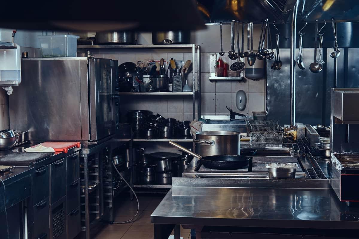 Industrial kitchen setup showing equipment and utensils, illustrating the pros and cons of ghost kitchens.