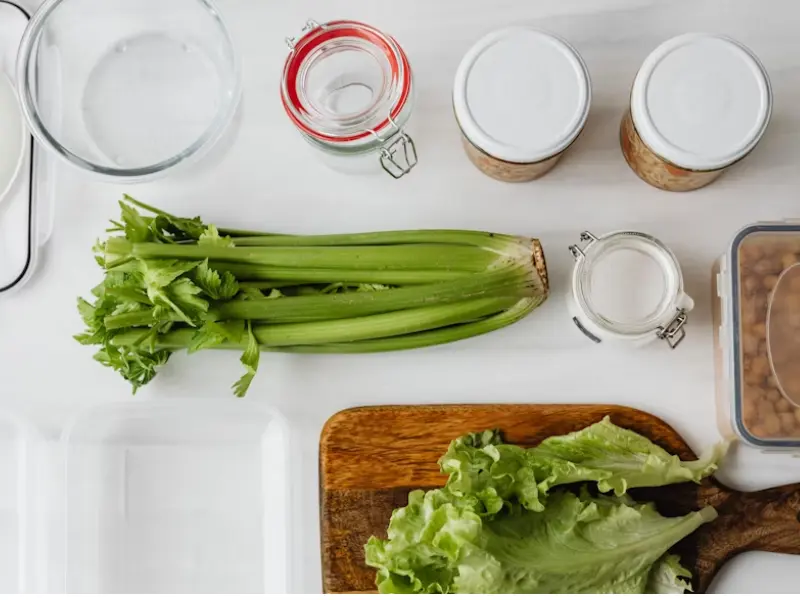 Fresh vegetables and sealed containers neatly arranged on a clean surface for a food hygiene inspection in a commercial kitchen.