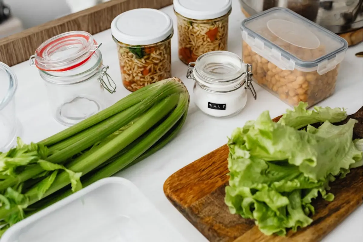 This image shows a clean kitchen counter with various fresh and stored food items, likely prepared for a meal or food hygiene inspection.