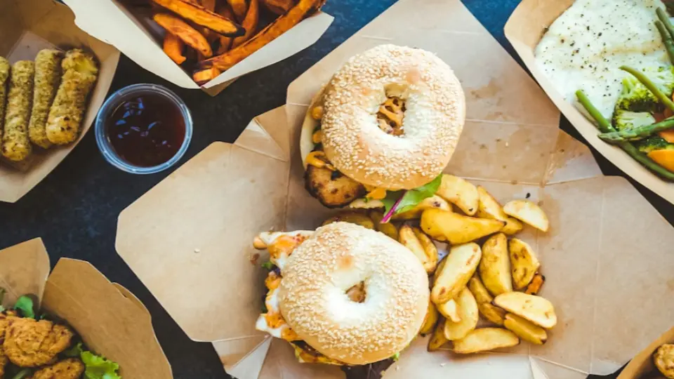 This is an inviting photograph of a table spread with various dishes, including sweet potato fries, nuggets, and mozzarella sticks.