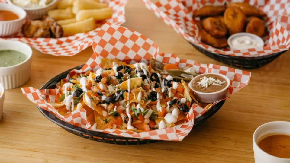 This image shows a variety of casual dining dishes served in baskets on a light wooden table.