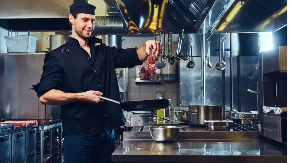 This image captures a chef in the middle of a high-energy cooking task.
