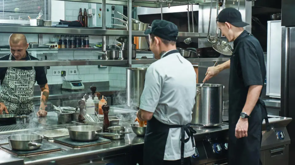 This wide shot captures the collaborative environment of a professional kitchen.