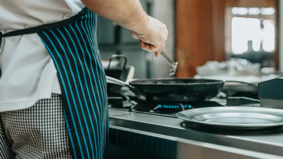 This image captures a candid, "in-the-moment" perspective of a chef working at a hot station in a professional kitchen.