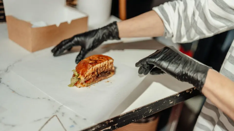 This image focuses on the final preparation or packaging stage of a gourmet slider.