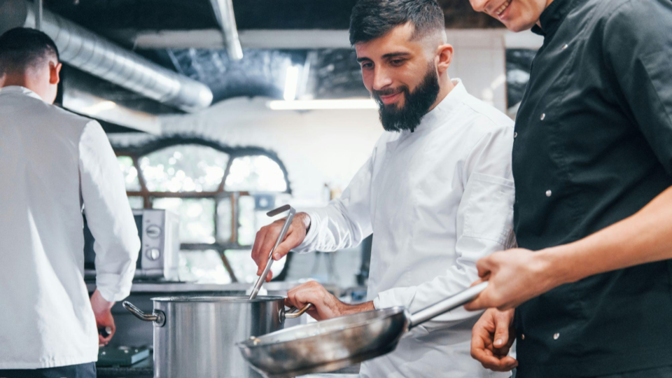 This image captures a positive and collaborative moment within a modern professional kitchen.