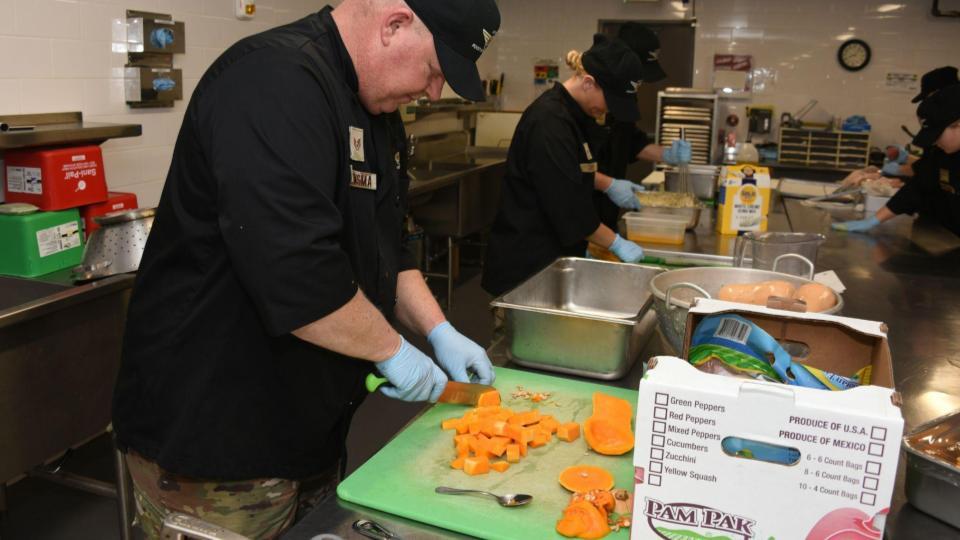 This image shows the behind-the-scenes kitchen operations, focusing on a team of chefs preparing fresh ingredients.