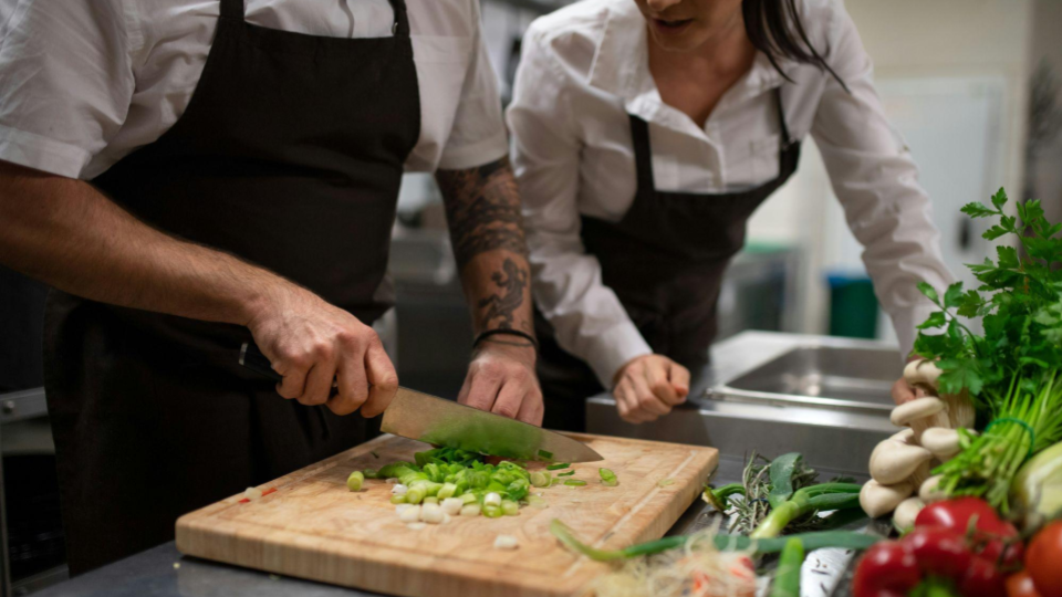 This is a close-up, low-angle shot that puts the viewer right at the prep station. It captures the initial steps of preparing ingredients.
