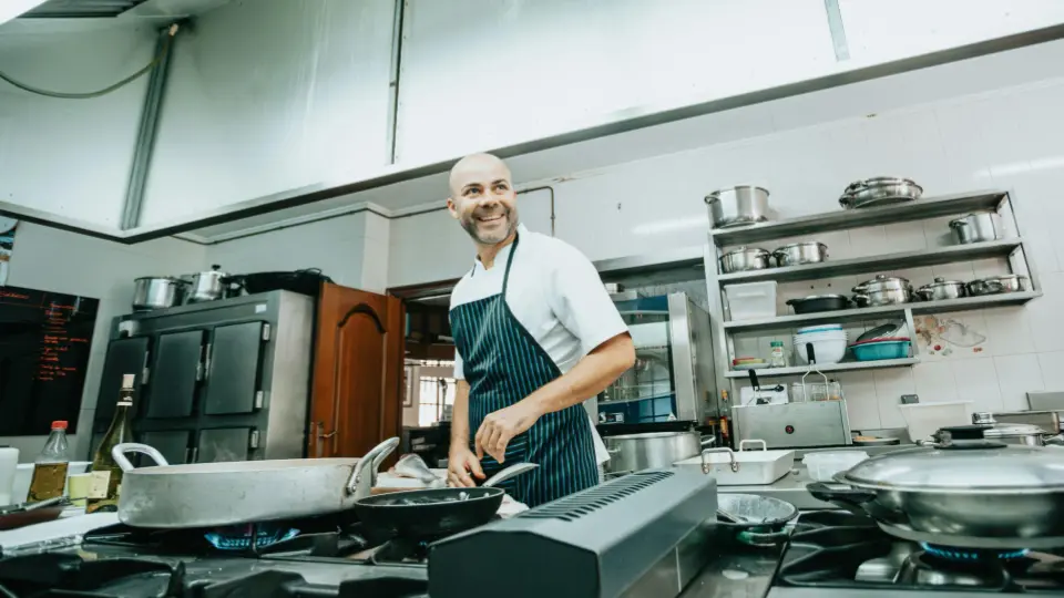 This wide-angle shot provides a view of a large, well-equipped professional kitchen.