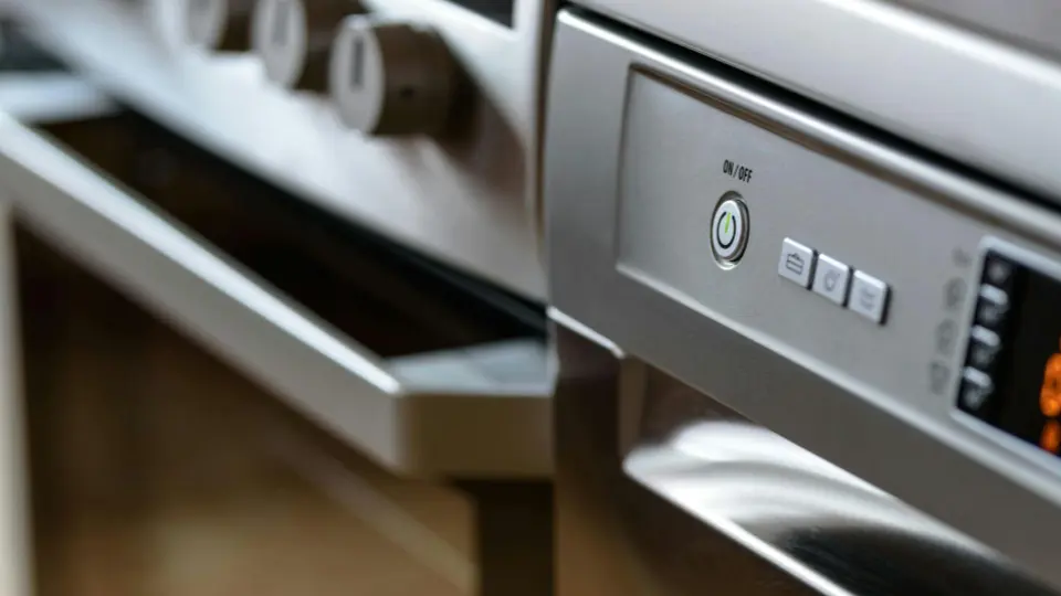 This image features a high-angle, shallow-depth-of-field shot of a modern kitchen appliance, likely a dishwasher or a high-end oven.