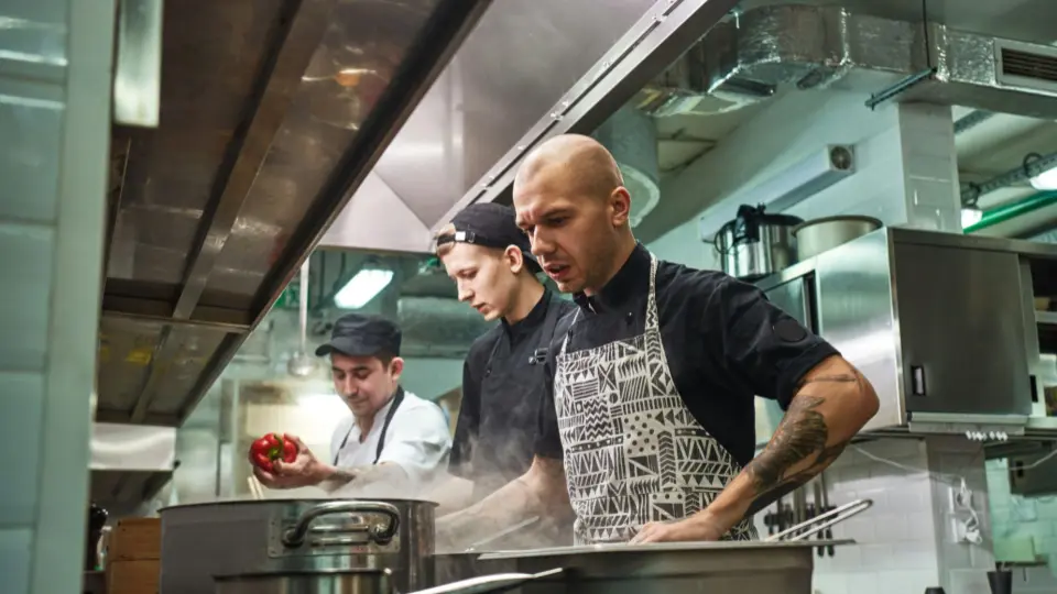 This image captures the high-energy environment of a professional commercial kitchen.