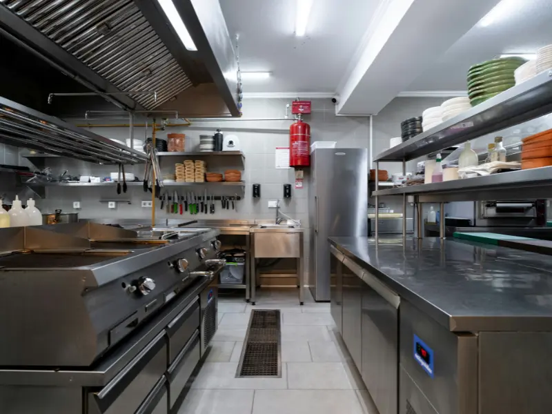 The image presents an interior view of a well-organized, spacious commercial kitchen or food preparation area.