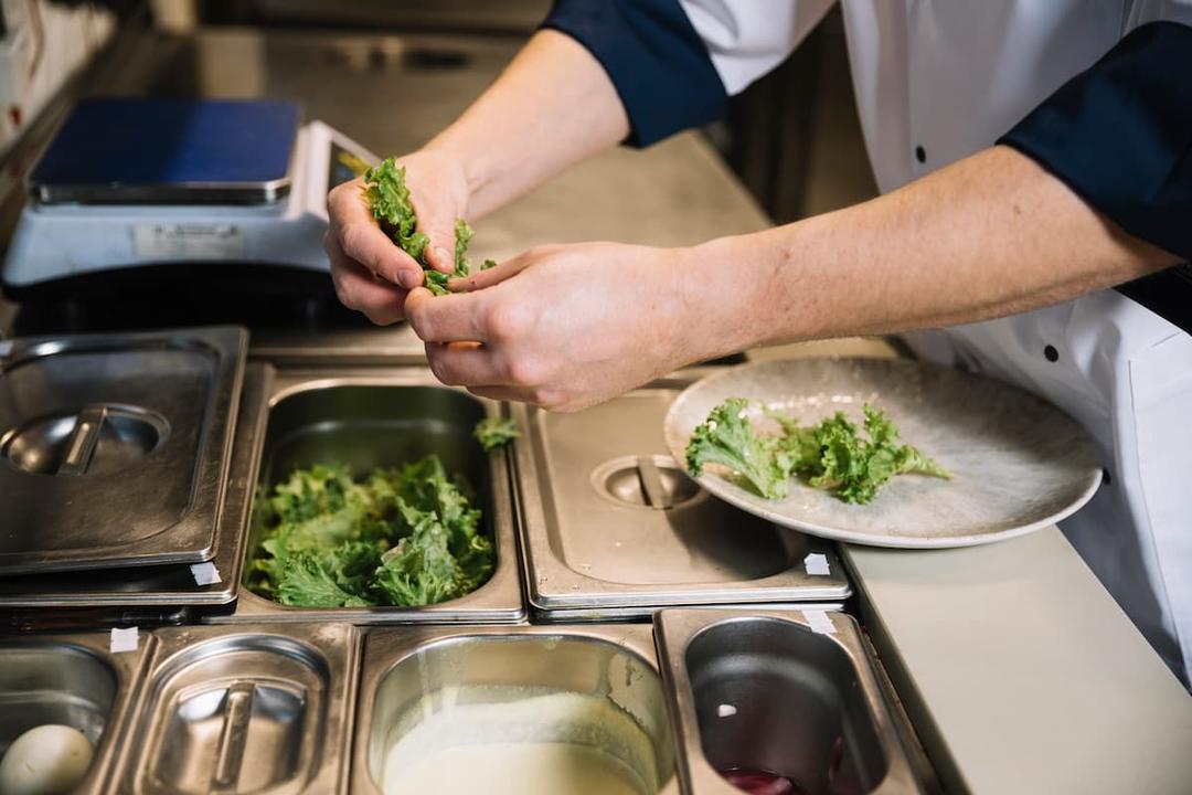Chef preparing salad, showing eco-friendly practices in delivery-only kitchens by minimizing ingredient waste.