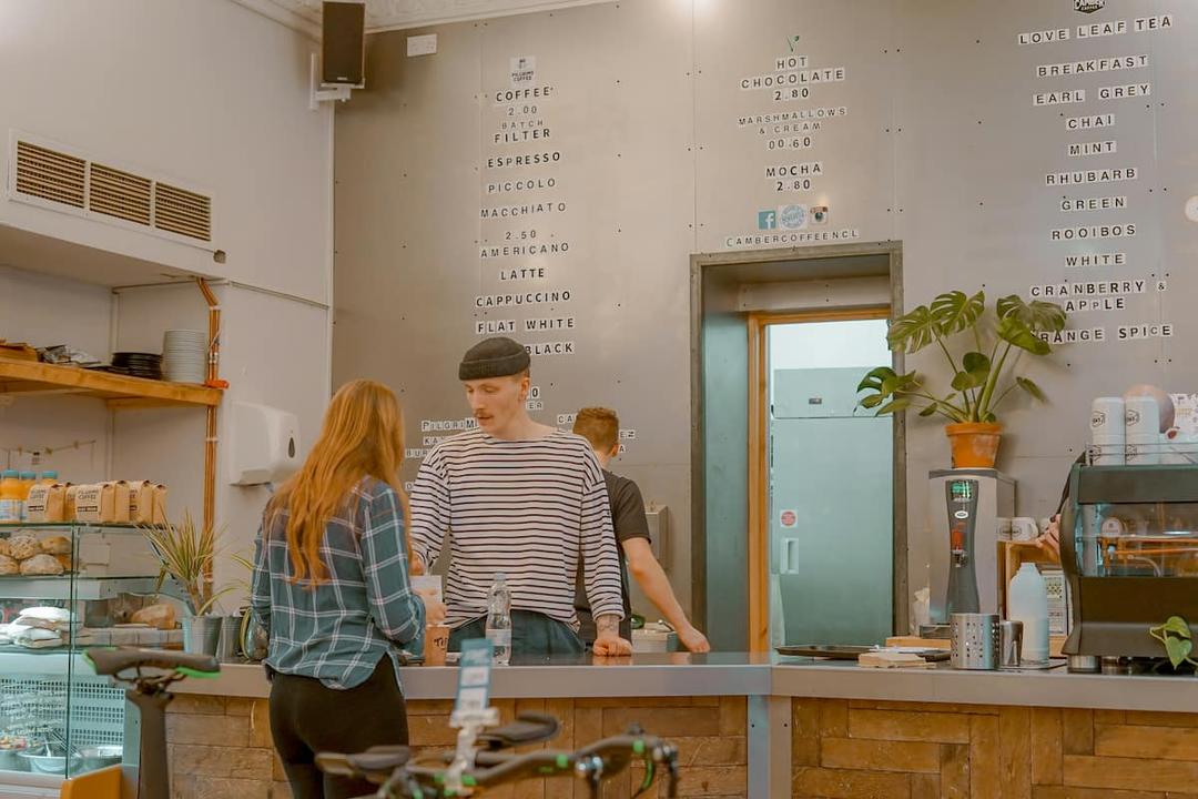 Barista talking to a customer at a café counter, a real-life example of how to handle customer complaints with care.