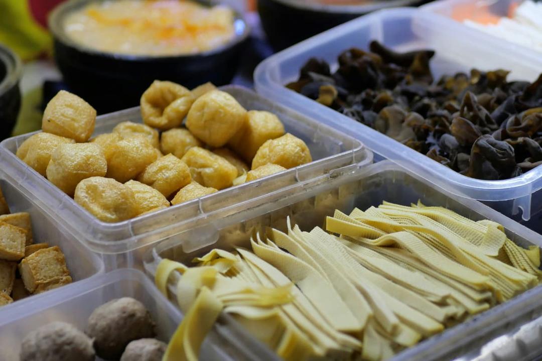 Assorted ingredients in plastic containers showing the importance of bulk kitchens for Asian cuisine preparation and efficiency.