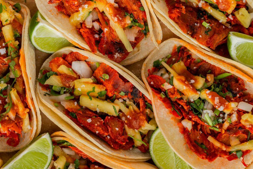 This is a top-down, close-up shot of several Tacos al Pastor.
