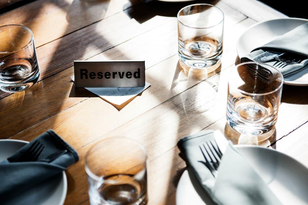 Restaurant table with a reserved sign, glasses, and table accessories