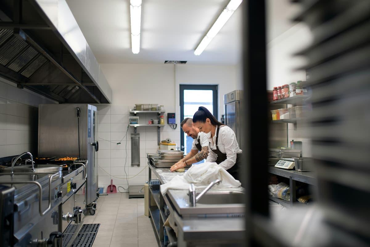 Two chefs working in a commercial kitchen, illustrating the concept behind why are ghost kitchen so popular for food startups.